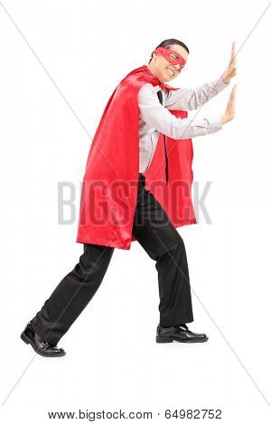 Male superhero mimicking that he is pushing something isolated on white background