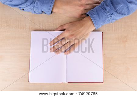 Men reading empty open book on wooden table background