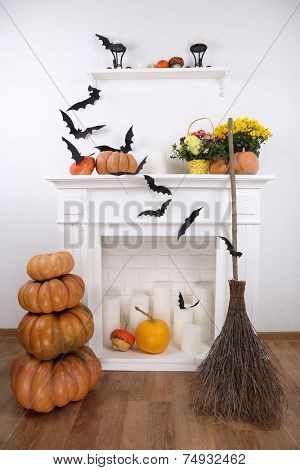 Halloween composition on fireplace in room