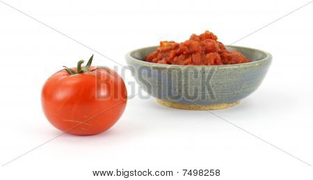Pomodoro maturo e ciotola dei pomodori schiacciati
