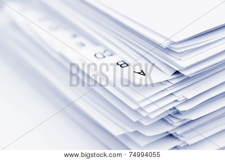 Stack of papers in alphabetical order, focus on letter A