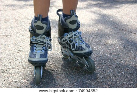 Young teenage girl wearing gray and blue rollerskates