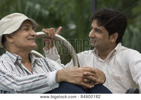 Father and son smiling in a park