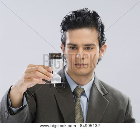Businessman looking at an hourglass