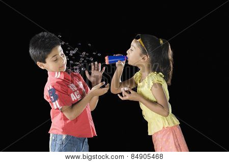 Girl blowing bubbles towards a boy