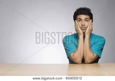 Man looking serious with his head in his hands