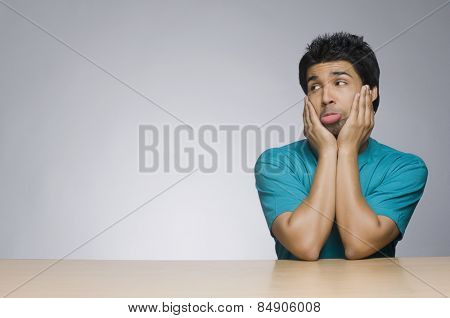 Man looking sad with his head in his hands