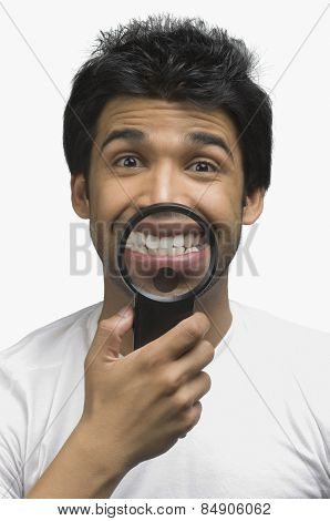 Man smiling in front of a magnifying glass