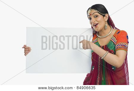 Woman in colorful lehenga choli holding a placard