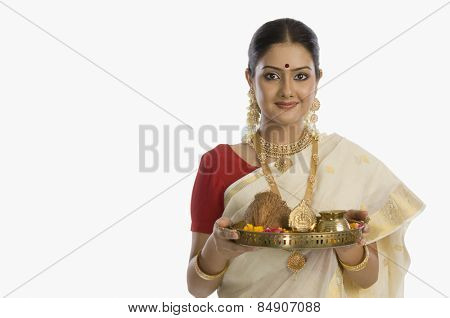 Portrait of a South Indian woman holding a plate of religious offerings