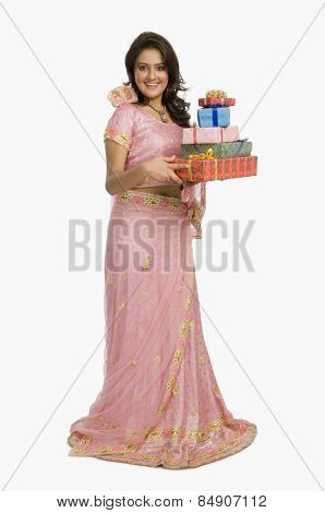 Portrait of a beautiful woman in traditional dress holding gifts and smiling
