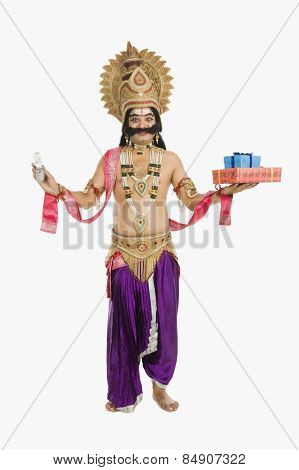 Indian man dressed-up as Ravana holding mobile phone and gifts