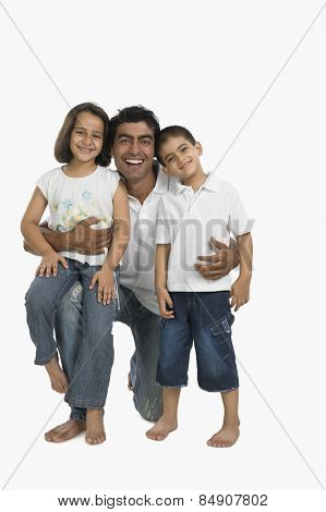 Portrait of a father hugging his children