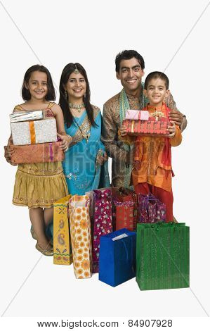 Family holding shopping bags and gifts for Diwali