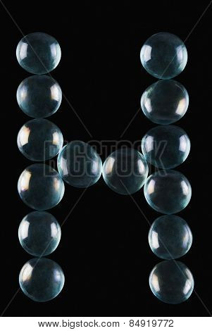 Close-up of marble balls arranged in the shape of letter H