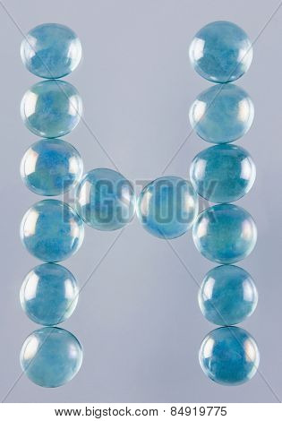 Close-up of marble balls arranged in the shape of letter H