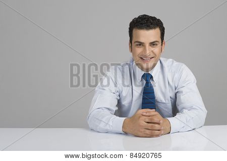 Businessman smiling with hands clasped
