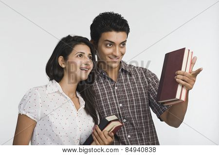 College students holding books and smiling