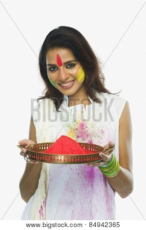 Woman holding Holi colors in a plate