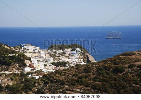 Buildings on a cliff with a clipper ship in the background, Ponza, Tyrrhenian Sea, Province Of Latina, Lazio, Italy