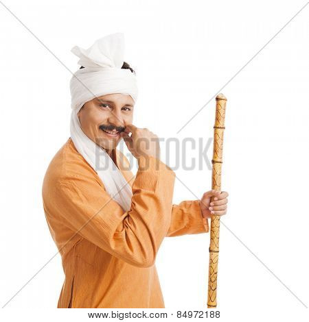 Portrait of a smiling man holing a staff and adjusting his mustache