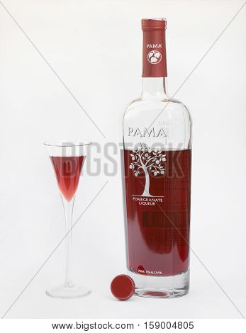 DAYTON, OHIO-NOVEMBER 29, 2016:Bottle of Pama Pomegranate Liqueur sits with cordial filled glass produced by PAMA Spirits Co. Bardstown, Kentucky with ingredients of pomegranate juice, vodka & tequila
