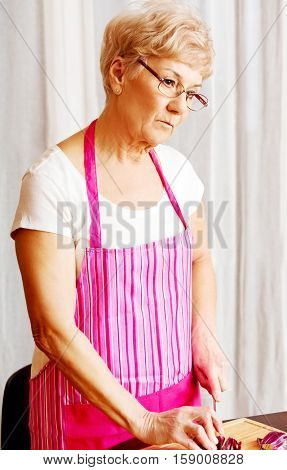 Woman cut red onion on cutting board