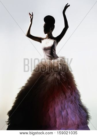Art fashion studio photo of beautiful elegant woman in luxury evening dress. Drawing of shadows and light. Light and color effects. Fashion style
