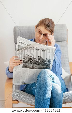 PARIS FRANCE - NOV 29 2016: Woman reading Le Monde newspaper with headline articles about Fidel Castro Cuban President - dead on November 25 2016 and Cuban situations
