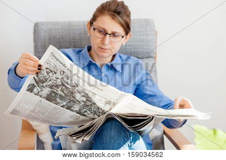 PARIS FRANCE - NOV 29 2016: Woman reading in armcharir Le Monde newspaper with headline and articles about Fidel Castro Cuban President - dead on November 25 2016