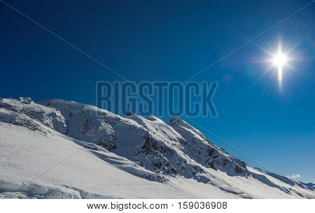 Alpine winter mountain landscape. French Alps covered with snow in sunny day. Val-d'Isere, France