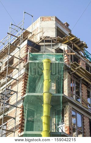 New construction with metal scaffolding and plastic debris chute