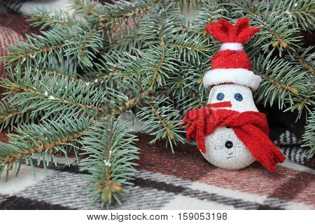 Snowman made from light bulb near Christmas tree