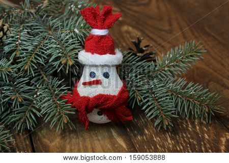 Snowman made from light bulb near Christmas tree