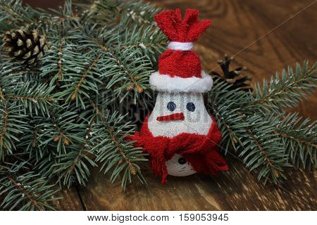 Snowman made from light bulb near Christmas tree