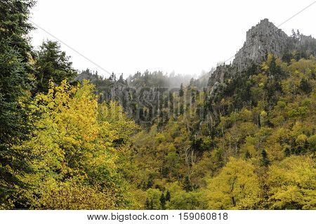 Stark granite peaks above bright foliage near Dixville Notch in New Hampshire