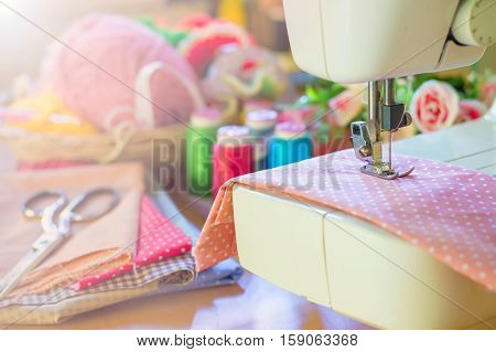 Close up of sewing machine working with pink fabric