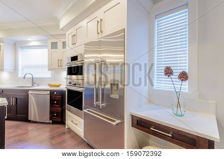 Modern, bright, clean, kitchen interior with stainless steel appliances in a luxury house