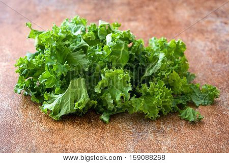Fresh green superfood kale leaves on rusto background