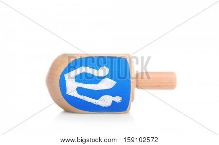Wooden dreidel for Hanukkah on white background