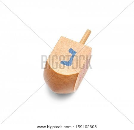 Wooden dreidel for Hanukkah on white background