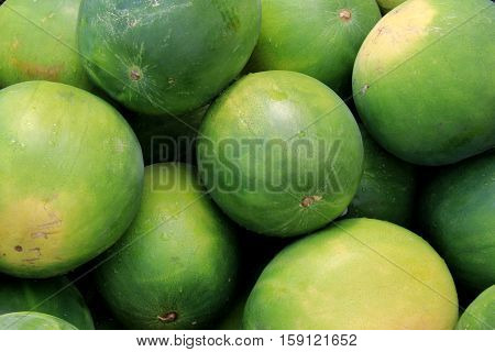 Horizontal image of several whole watermelons stacked together
at local farmers market.