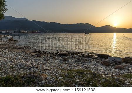 Amazing Sunset view with old boat in the sea of Thassos town, East Macedonia and Thrace, Greece