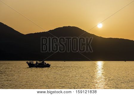 Amazing Sunset panorama with old boat in the sea of Thassos town, East Macedonia and Thrace, Greece