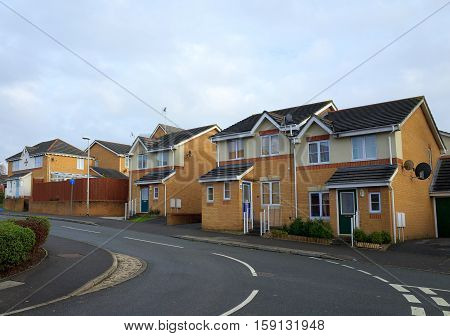Bracknell,England - November 23, 2016: A row of brick built homes on a modern housing estate beside a road in Bracknell, England