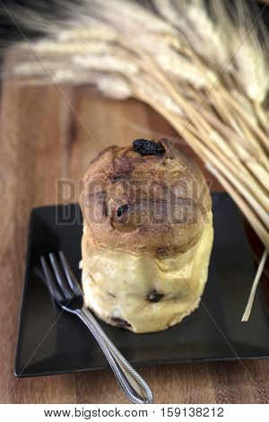 Miniature Italian sweet bread served on a black square dish and accompanied by a pot of green tea