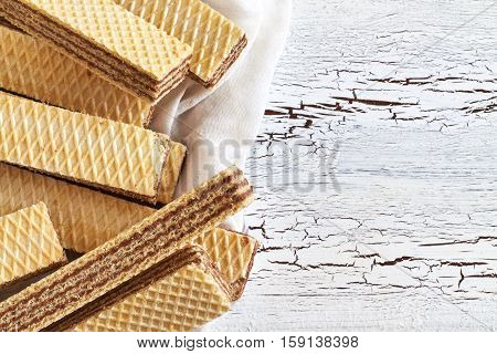 Wafer biscuits with chocolate cream on white rustic wooden background. Top view with copy space
