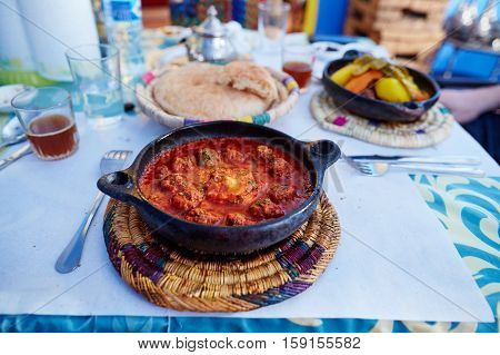 Traditional Moroccan dish kefta tajine with meat balls and baked egg in tomato sauce