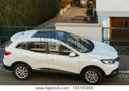 STRASBOURG FRANCE - NOV 29 2016: Aerial view of a white Renault Kadjar SUV car parked near a beautiful house. Renault is the bigest French automobile maker
