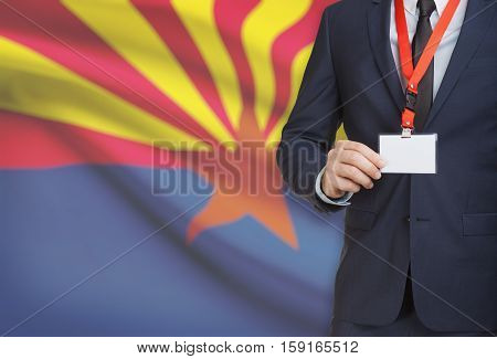 Businessman Holding Badge On A Lanyard With Usa State Flag On Background - Arizona